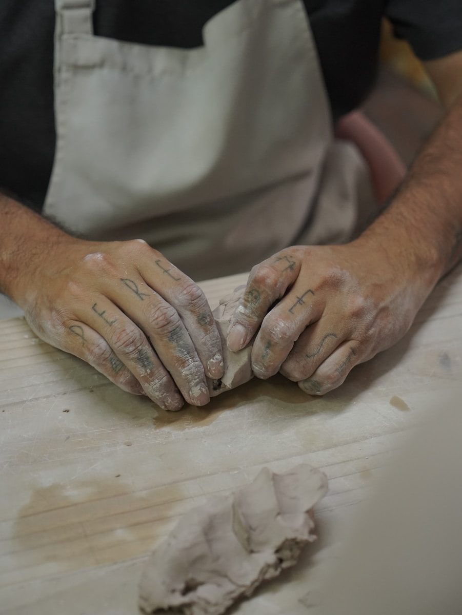 A person is shaping clay with their hands